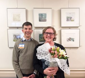 Artist, Lori Hinrichsen with ED doctor, John "Nez" Nesbitt in front of artwork