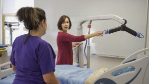 NVRH Director of Nursing Education Britta Hensel demonstrates medical equipment to a student.